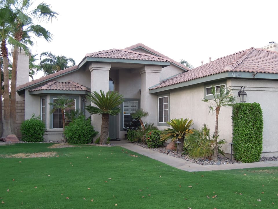 Front view of home, grass no longer green  due to drought.
