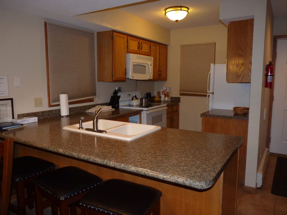 large kitchen with bar stools for sitting at the counter