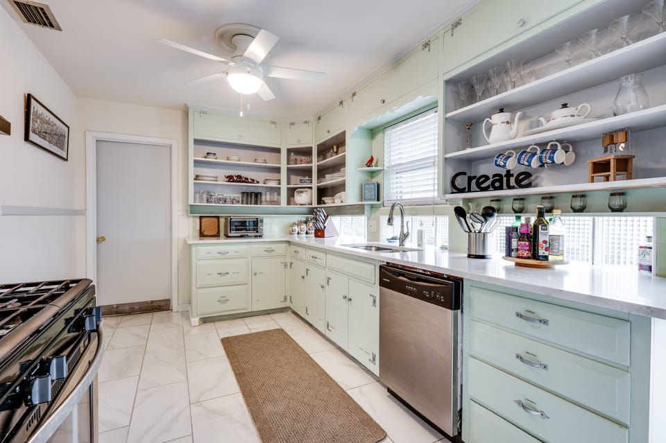 Quartz counter, stone floors, and gas cooktop.  

Well-stocked kitchen.