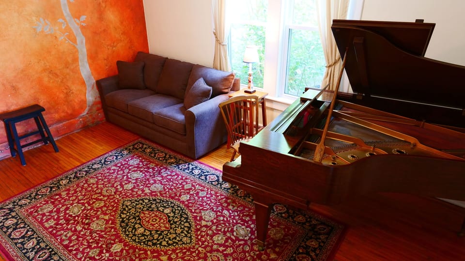 This secondary living room/ music room features a stunning grand piano.