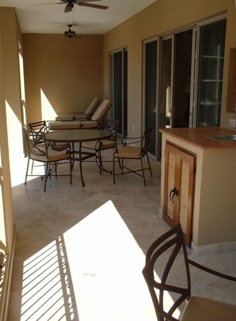 Balcony with loungers, 2 tables, wet bar.