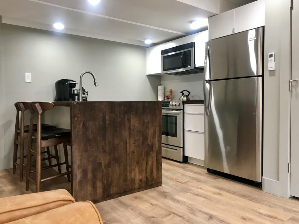 Well-equipped kitchen with ice maker, Keurig, grinder, and French press.