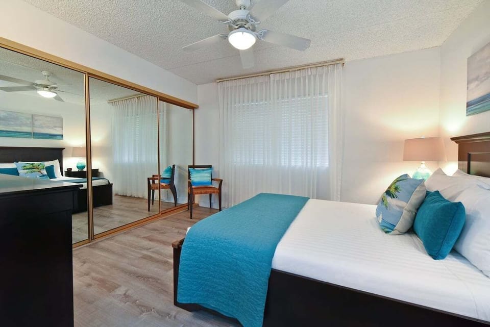 Bedroom with mirrored closet doors and window for natural light.
