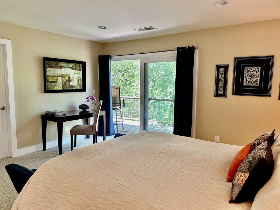 Primary bedroom upstairs with ensuite bathroom and direct access to upper deck.