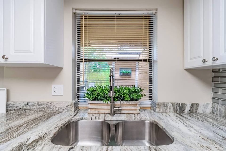 Double stainless steel sink with garbage disposal with a view to the outdoor living space