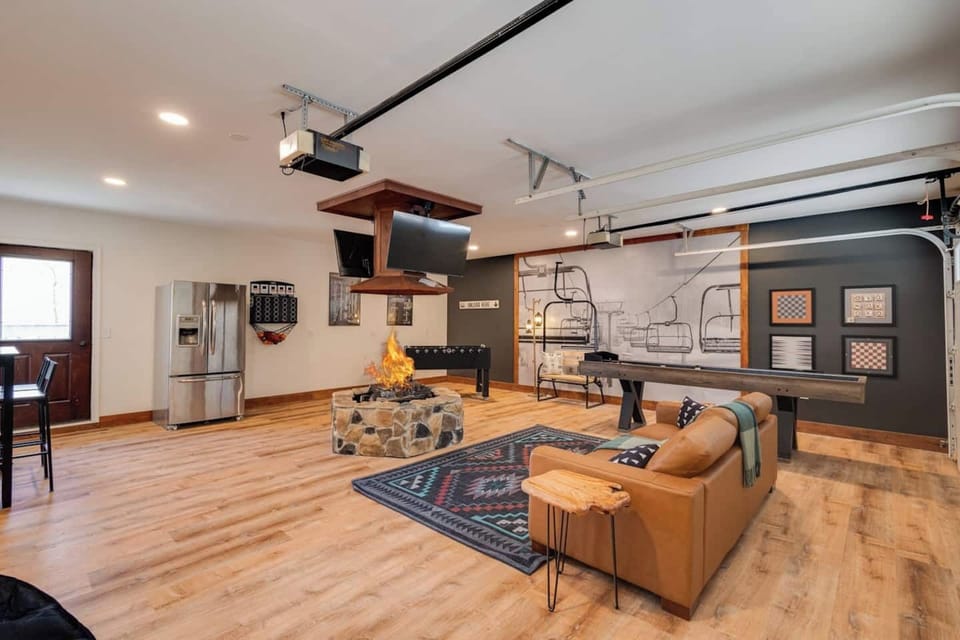 Brand new Game room with Indoor ventless Firepit, shuffleboard, foosball, 2nd fridge, and flat screen TVs to catch every game and event!