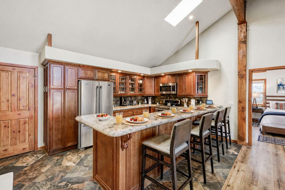 gather in your spacious kitchen featuring warm wood cabinetry, granite counters, and bar seating for memorable meals together.
