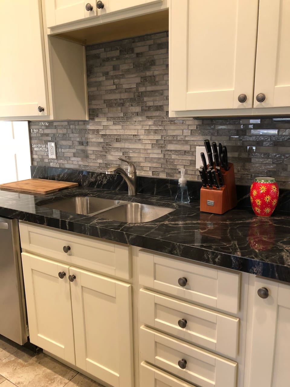 Brand new kitchen with stainless appliances is fully stocked for meal prep.