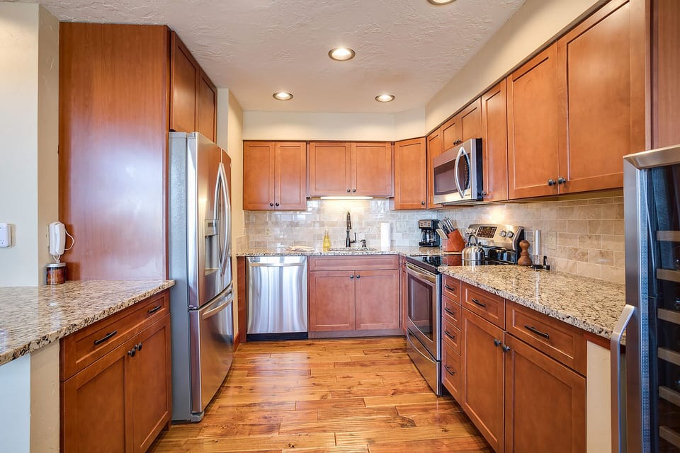 Your gourmet kitchen features rich wood cabinetry, granite countertops, and premium stainless steel appliances for memorable meal preparation.