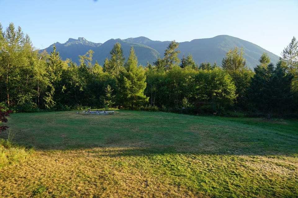 Back Yard with firepit: acres of flat land for events. Views forest & mountains.