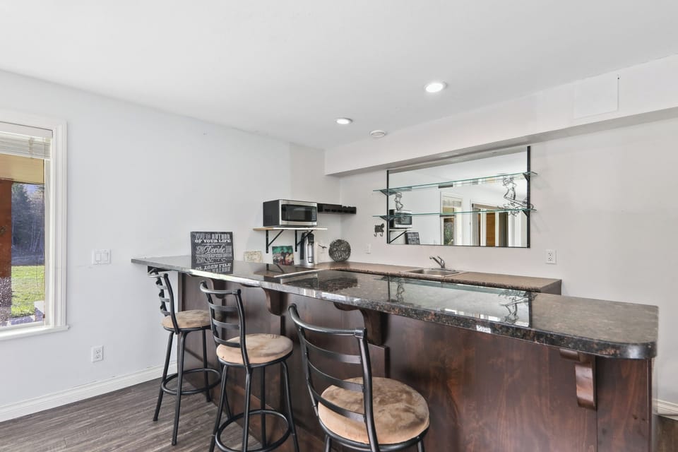 Games Room Bar with high chairs, fridge, microwave, sink.