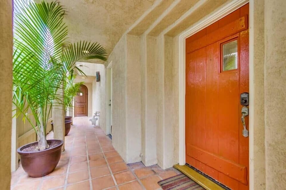 Beautiful terra cotta walkway lined with palms extends the length of the house.
