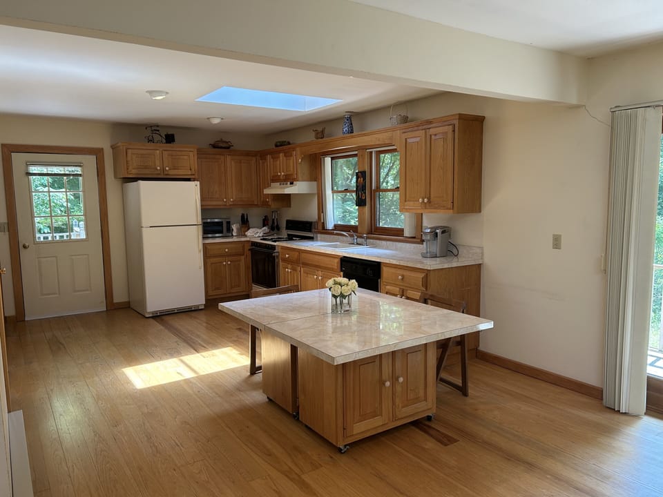 Full size kitchen with refrigerator and gas oven.