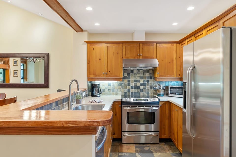 A fully equipped kitchen with granite countertops and modern appliances.