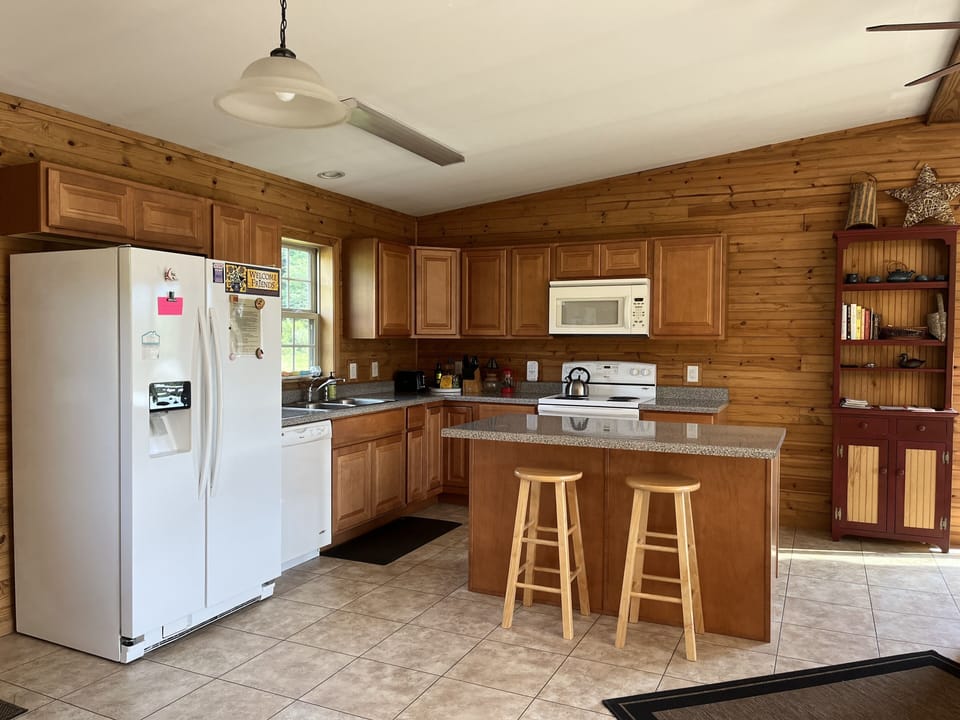Kitchen area with island, Microwave, dishwasher, stove, and fridge.