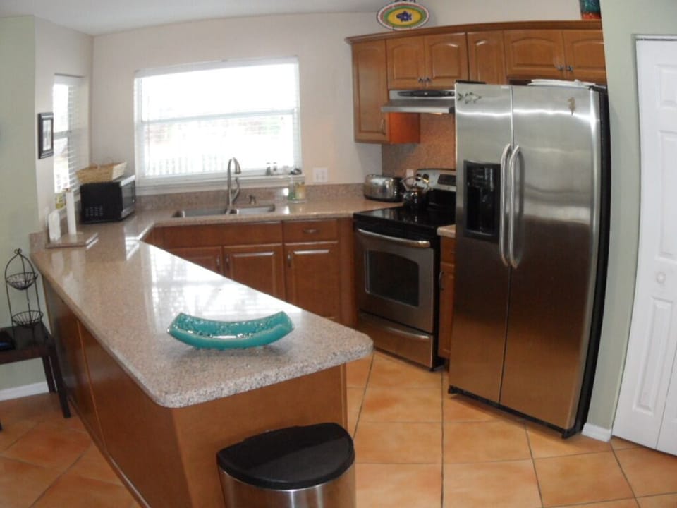 Quartz countertops and wood cabinet  kitchen with stainless appliances