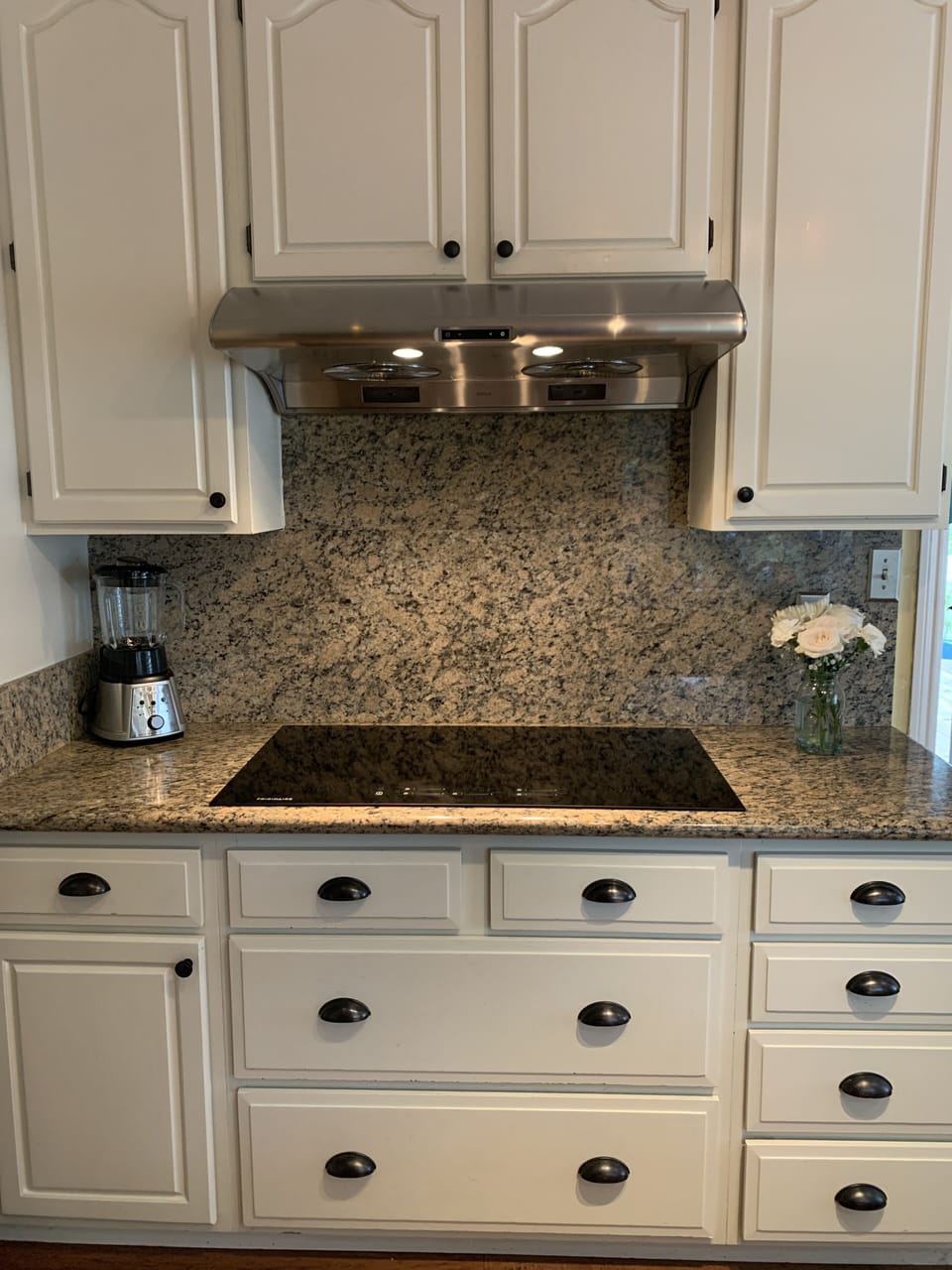 Large kitchen offers granite counters and induction cook top with five elements