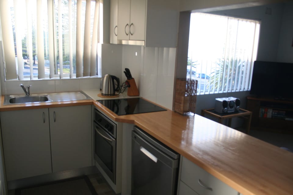 Modern kitchen with glass cooktop, full oven, dishwasher, microwave and fridge