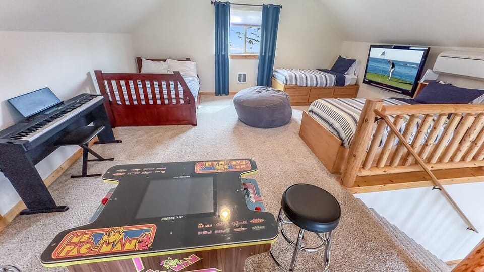 Upper Floor – Open Loft: Two Twin Beds + Full Bed with Trundle (Sleeping 5) + 60" Smart TV + Pac Man Arcade + Digital Piano
