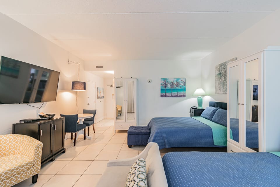 Two queen size beds, two mirrored armoires with draws, and 60” smart TV.