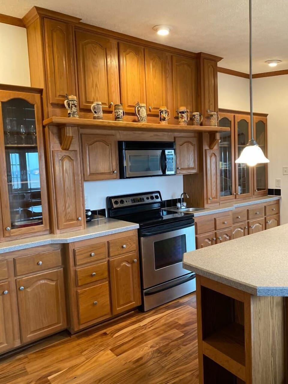 Kitchen view looking at electric stove and microwave oven