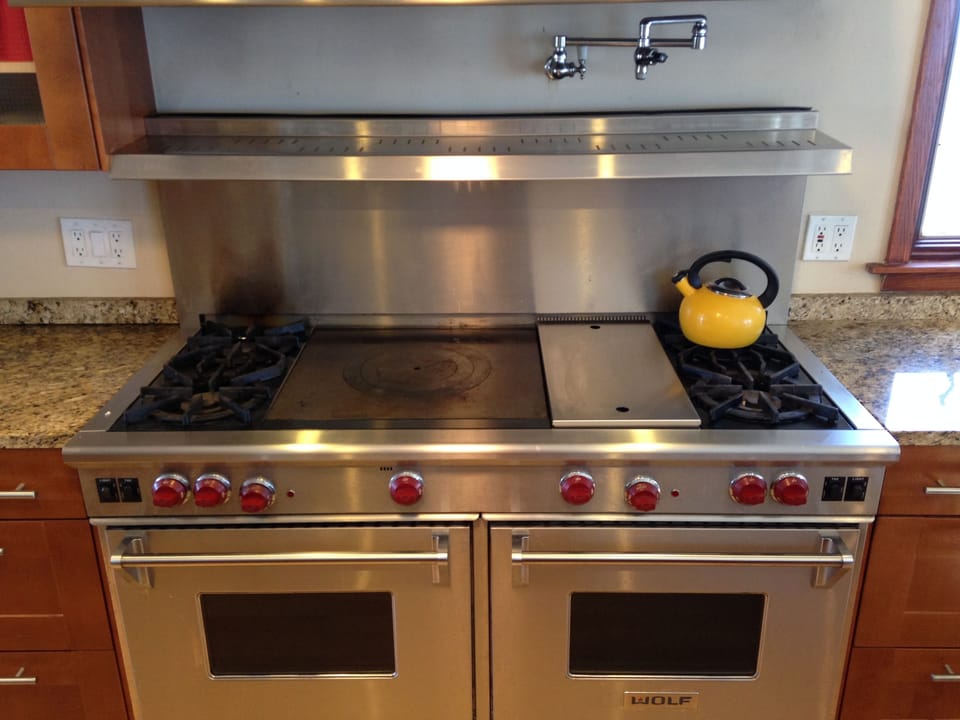wolf stove has two ovens, a french top, and a grill, plus 4 burners.