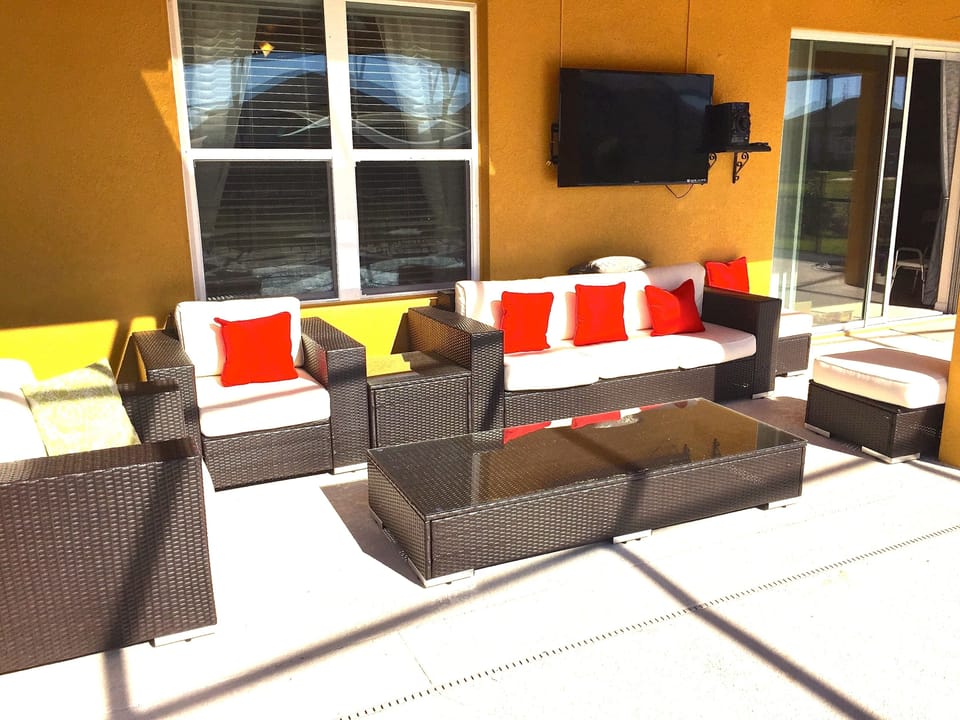 Out side Patio furniture under covered lanai with 55 inch TV.