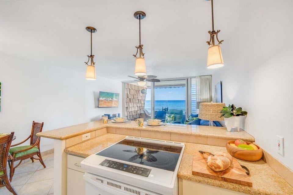 Kitchen with granite counters, bar seating, and ocean views beyond.