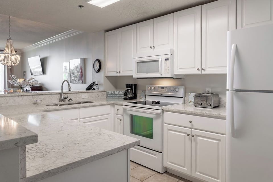 Kitchen - The kitchen features both small and large appliances and is fully stocked with all items needed for prepping and cooking meals during your stay.