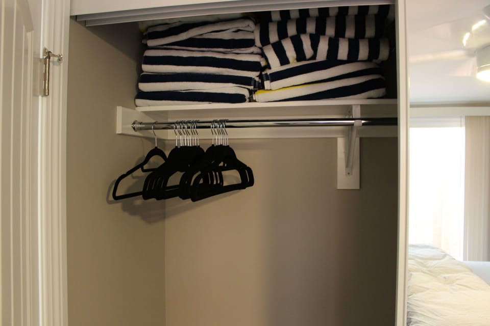 Master bedroom closet with beach towels provided for your convenience.