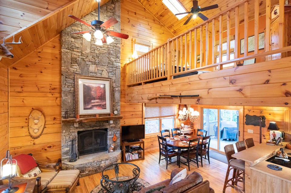 Open den with a stone wood burning fireplace