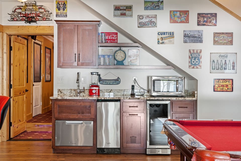 Snack bar with sink, blender, microwave, ice dispenser and fridge in game room