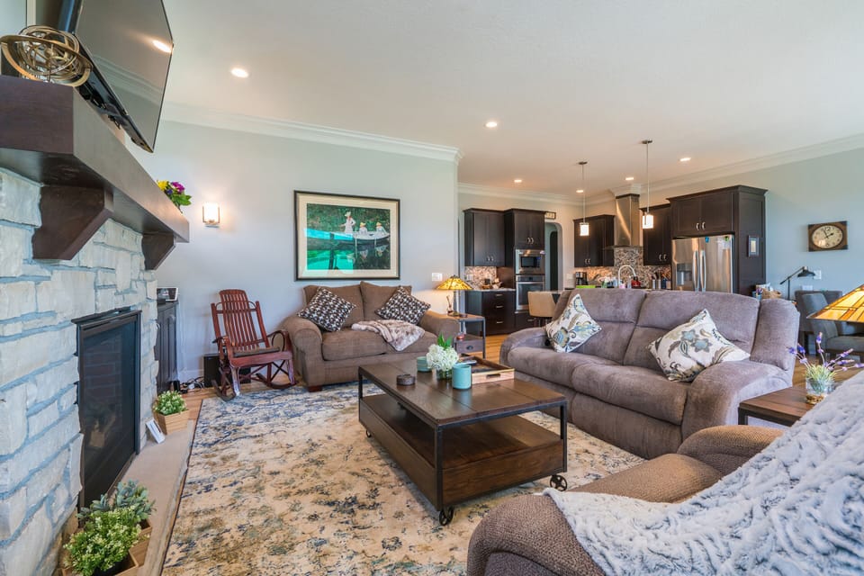 living room has 3 motorized reclining easy chairs around the fireplace.