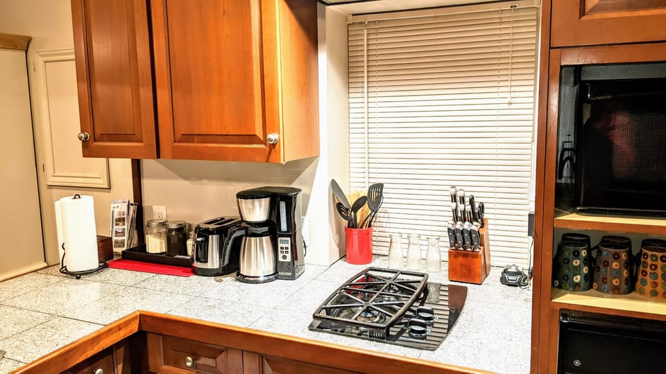 Full kitchen with pots, pans, cooking utensils and flatware. 