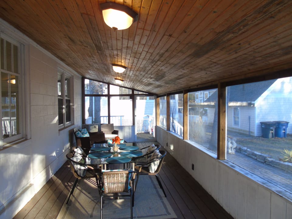 Screened in porch with table and chairs for 8, plus additional seating area