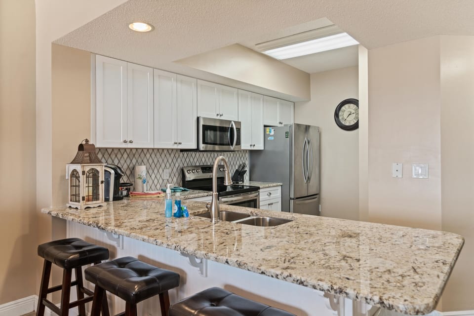 Fully stocked kitchen with new cabinets, new granite tops, and new backsplash.