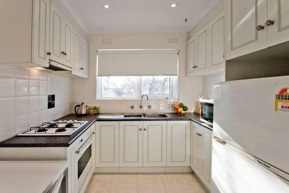 Kitchen has 4 burner gas cooktop with large family size fridge