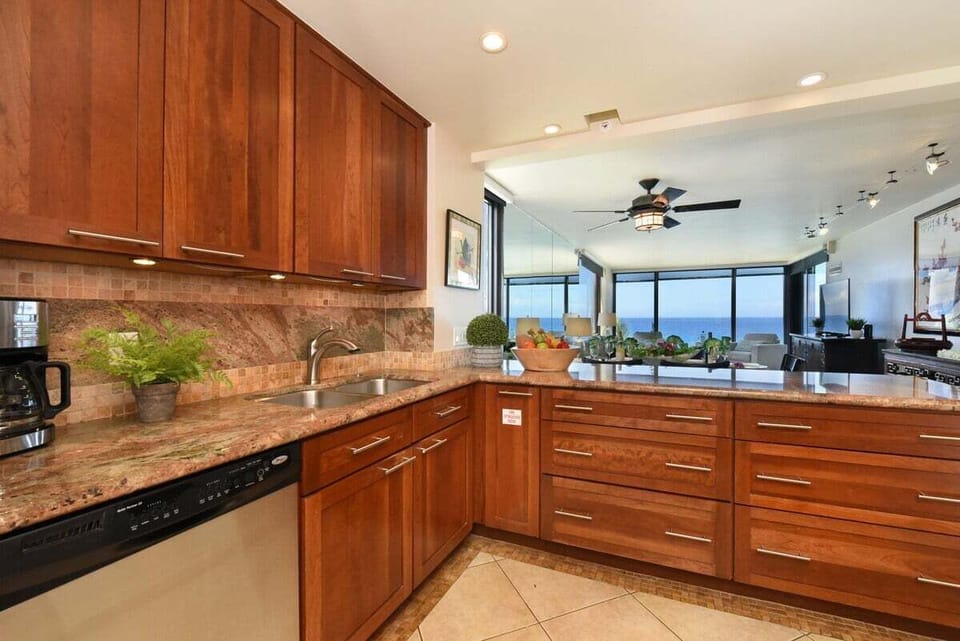 A warm and inviting kitchen with ample storage, sleek finishes, and breathtaking views of the sea