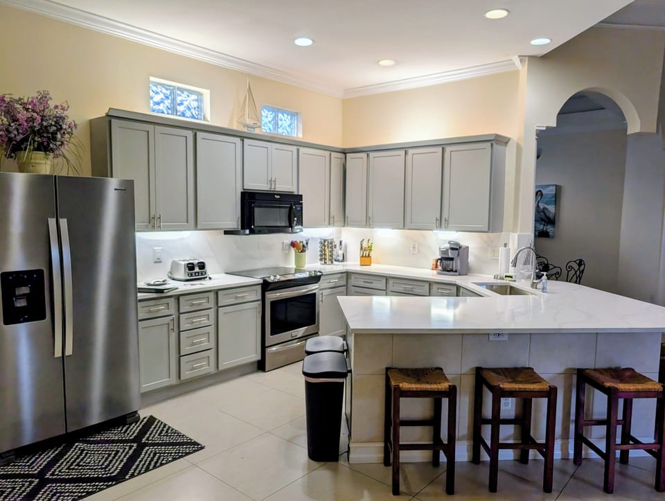 Upscale Kitchen, Quartz Countertops, fully stocked dishes and cooking utensils.