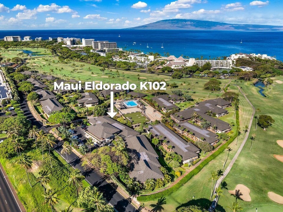 Aerial view of Maui Eldorado framed by lush golf course greens and shimmering ocean views