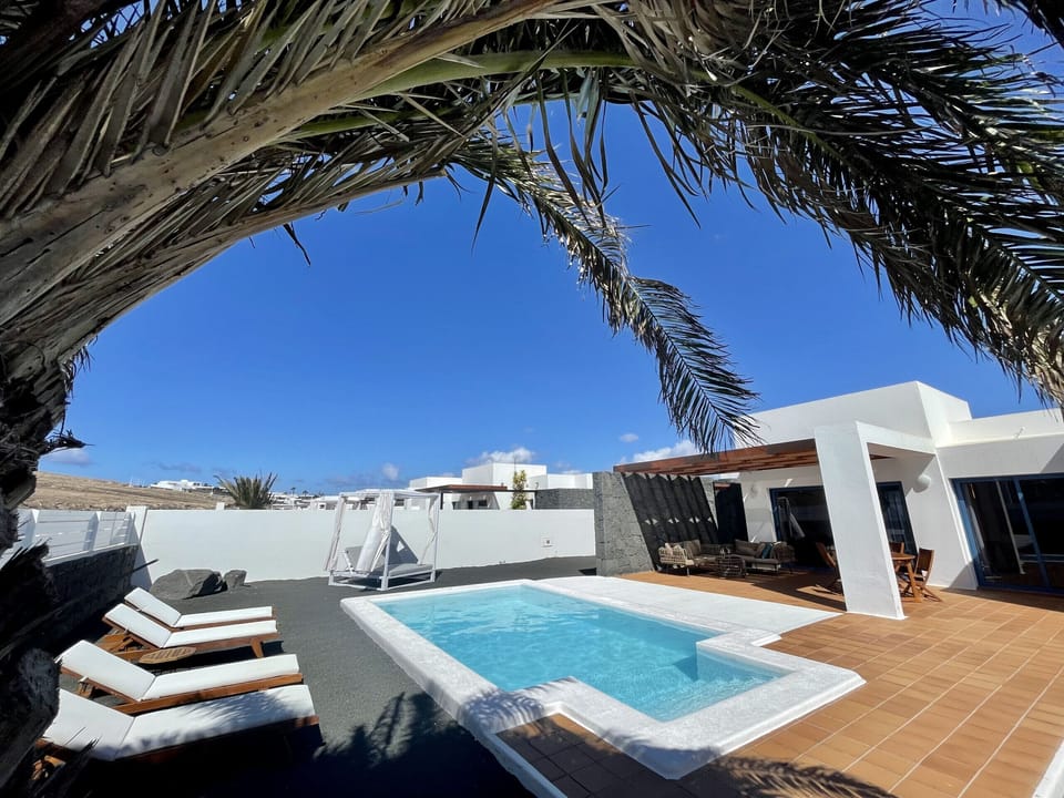 Large terrace with outdoor furniture and private pool heated by a heat pump