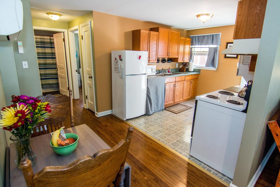 Another view showing kitchen, dining table, and hallway to bath and bedroom
