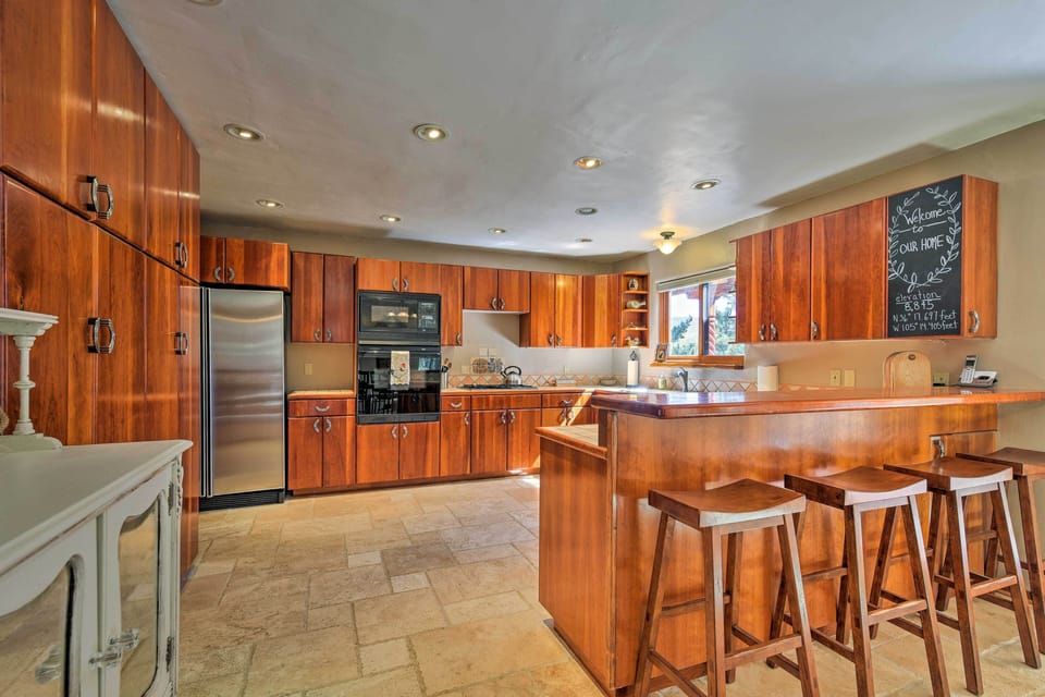 Tiled floors and sleek wooden cabinets detail the fully equipped kitchen.