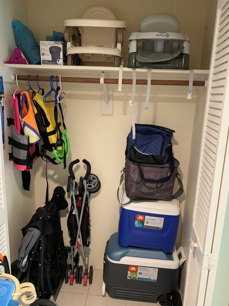 Two strollers, two portable high chairs, life vests and a variety of coolers.