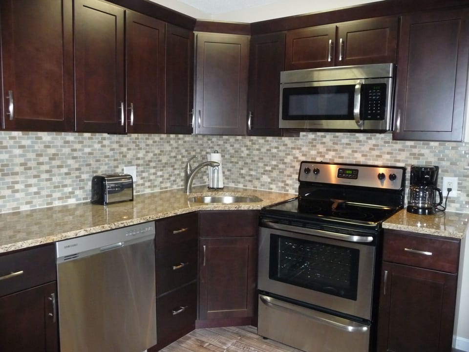 Espresso cabinets with granite countertops and stainless steel appliances
