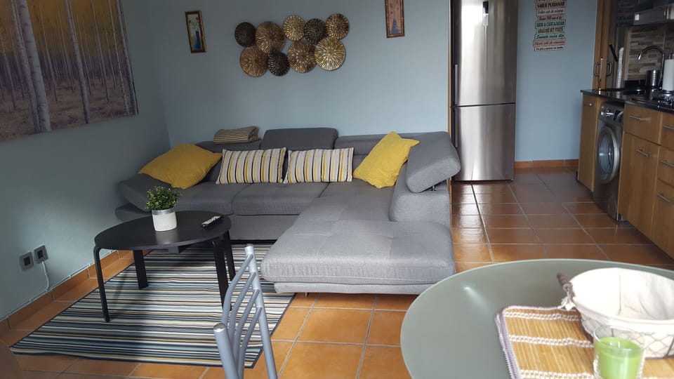 Living room with sofa, chaise longue and kitchenette