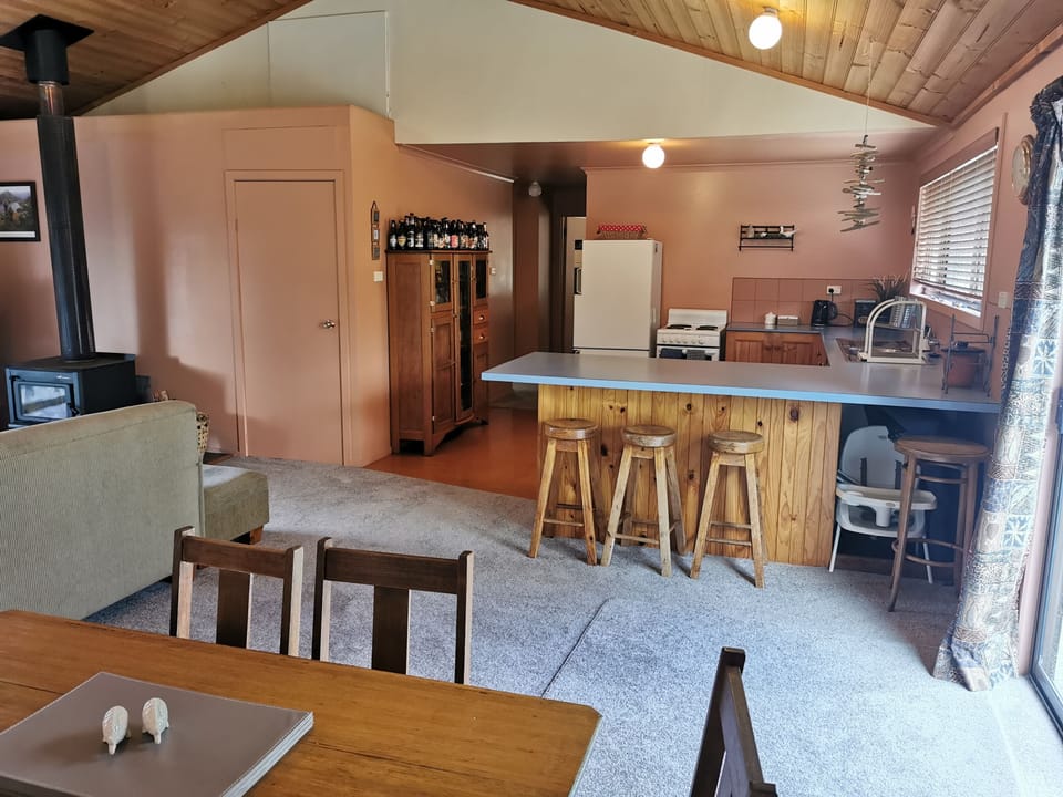 Portocot and high chair under kitchen bench on right.