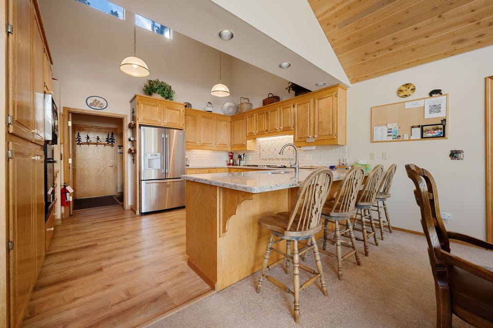 The kitchen offers stainless steel appliances and a breakfast bar for 4