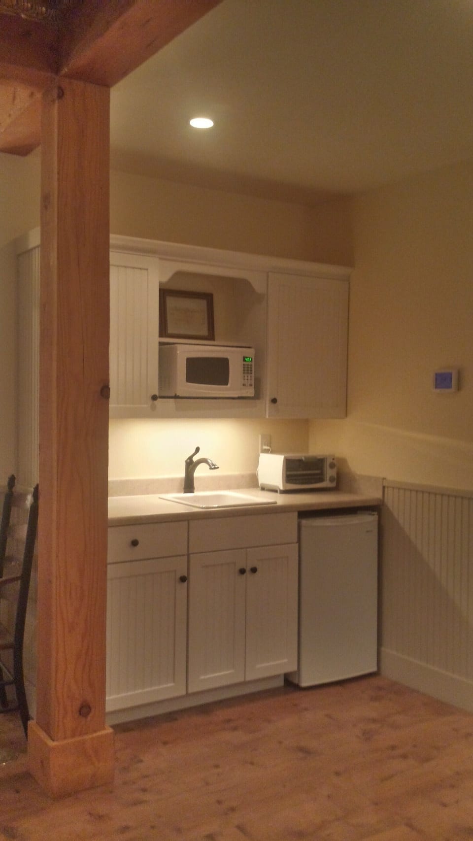 Kitchenette with microwave, coffee maker, toaster oven and small refrigerator.