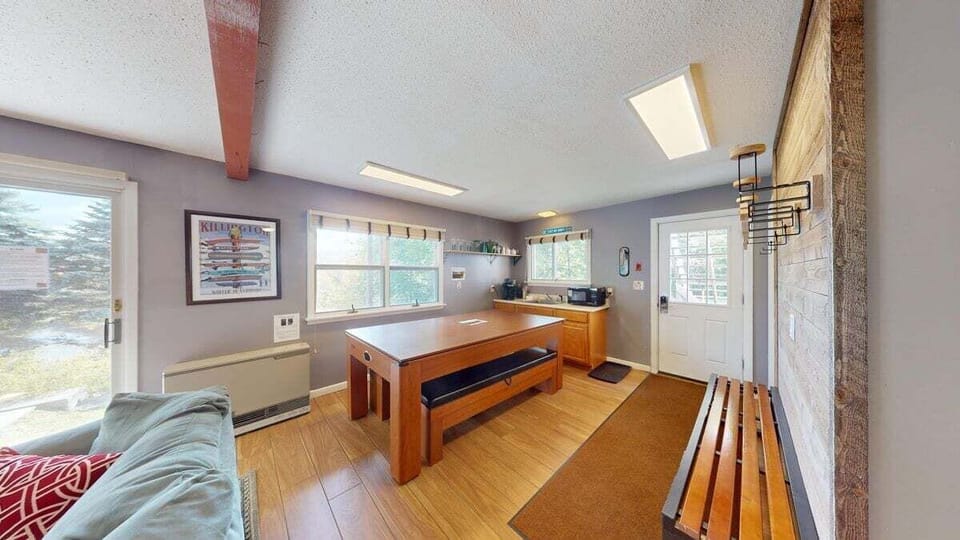 Spacious lower level hangout with game table seating and a kitchenette area for snacks and drinks.